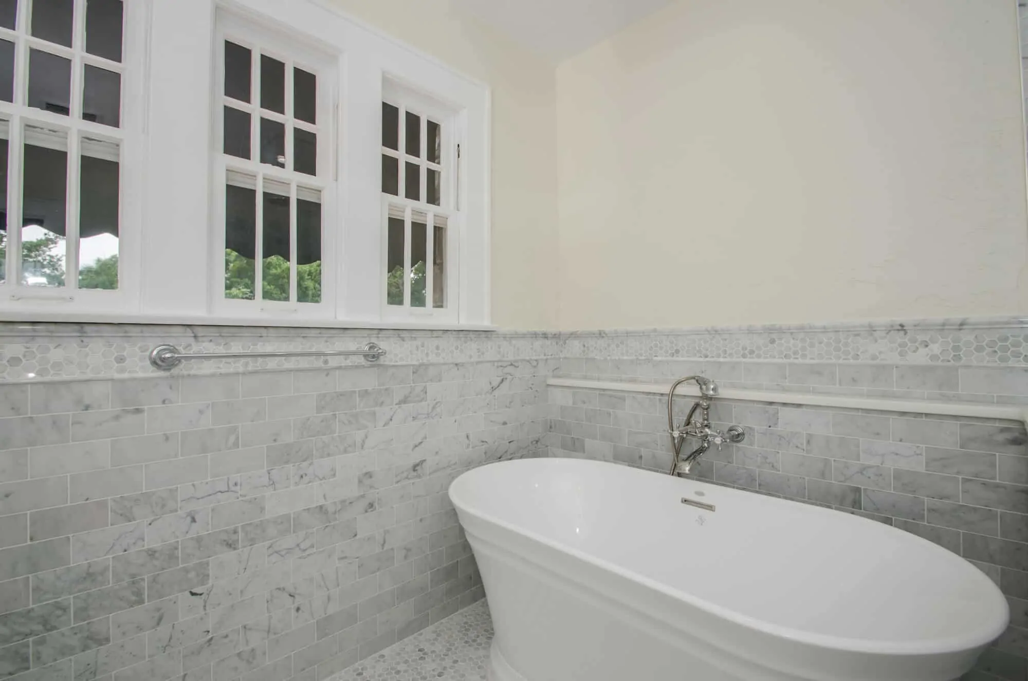 vintage style bath remodel featuring marble walls